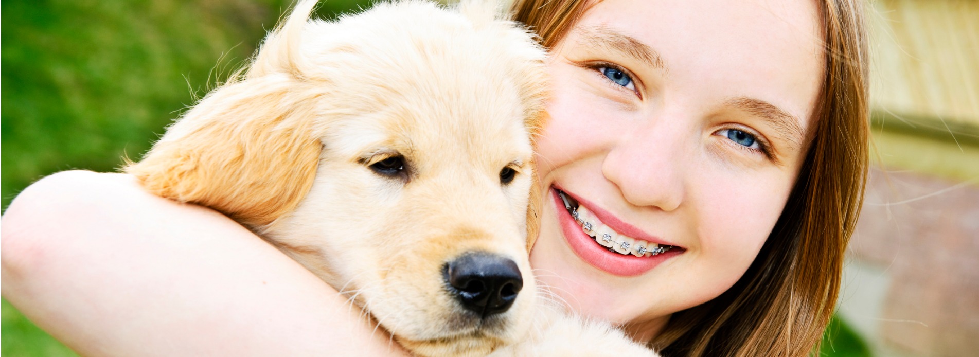 girl smiling holding a puppy dog picture