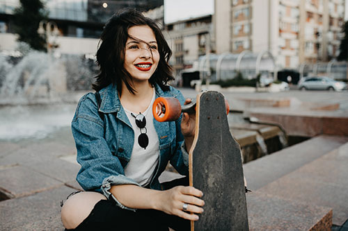 Smiling teen girl with skateboard